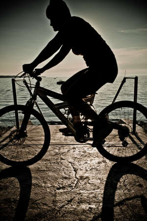 Mountain bike rider silhouette in beachの写真素材