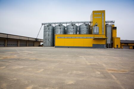 Cereal silos with a yellow buildingの写真素材
