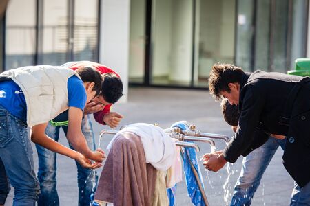 BUDAPEST - SEPTEMBER 7: war refugees bathing and drinking at Keleti Railway Station on 7 September 2015 in Budapest, Hungary. Refugees are arriving constantly to Hungary on the way to Germany.のeditorial素材