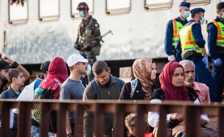 GYEKENYES- OCTOBER 5 : War refugees at the Gyekenyes Zakany Railway Station on 5 October 2015 in Gyekenyes, Hungary. Refugees are arriving constantly to Hungary on the way to Germany.のeditorial素材