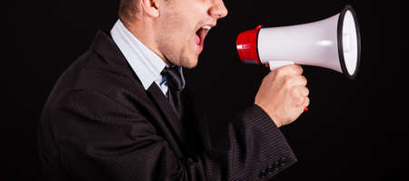 handsome businessman screaming in megaphoneの写真素材