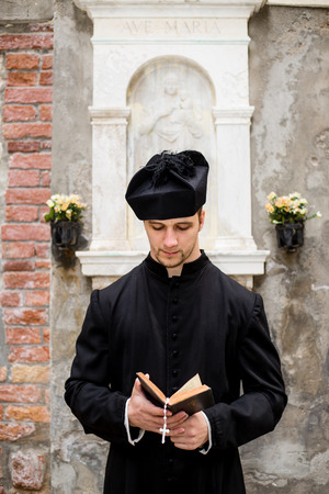 young priest in venice with churchの写真素材