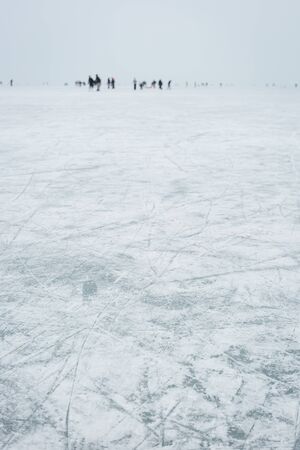 Ice skaters on lake focus on iceの写真素材