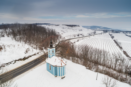 small blue chapel with snow near to Szekszardの写真素材