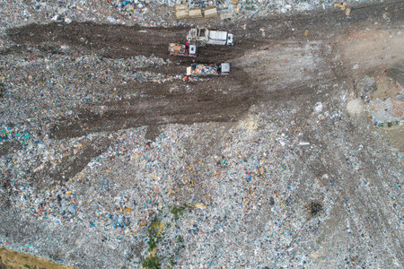 Garbage trucks unload garbage to a landfill, drone photo