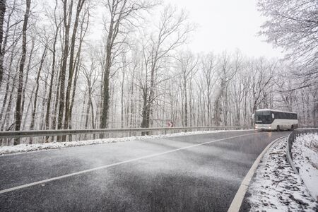 snowy road at cold wintertime with busの写真素材