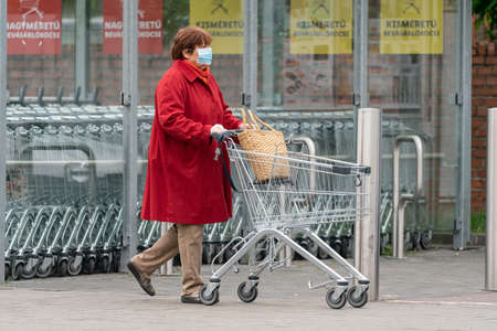PECS - MAY 27 : Old woman go to shopping on the street  on 27 May 2020 in Pecs, Hungary. During coronavirus pandemic, everybody have to waering face maskのeditorial素材