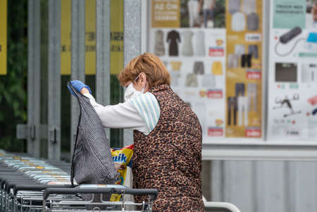 PECS - MAY 27 : Old woman go to shopping on the street  on 27 May 2020 in Pecs, Hungary. During coronavirus pandemic, everybody have to waering face maskのeditorial素材