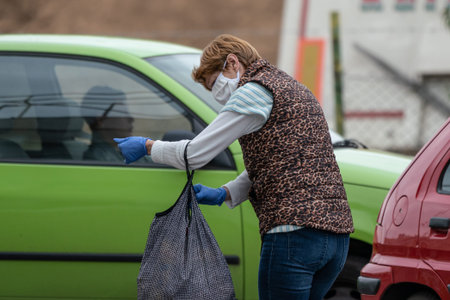 PECS - MAY 27 : Old woman go to shopping on the street  on 27 May 2020 in Pecs, Hungary. During...