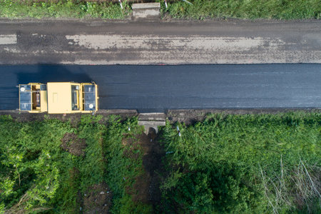 Aerial photo of road roller machine rolls asphaltの写真素材