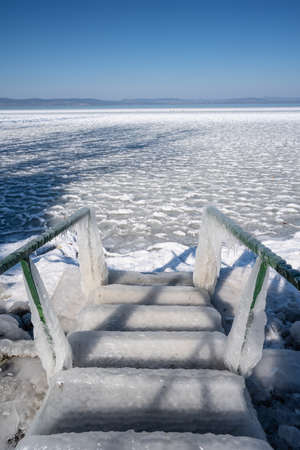 Beautiful frozen Lake Balaton with steel stepsの写真素材