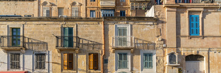 Traditional house detail in Malta. Limestone yellow bricks and colorful balconies, windowsの写真素材