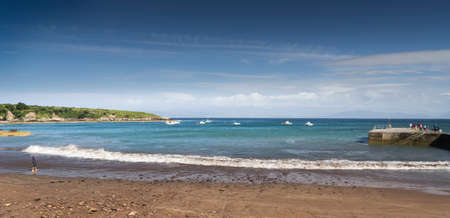 Panoramic scene of an Irish beach with people in summer and blue sky.のeditorial素材