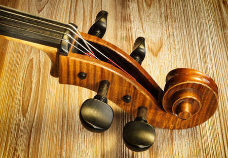 Neck and headstock of a cello with a textured woodenの写真素材