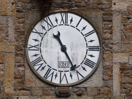 Old clock on the facade of an abandoned and ruined church.の写真素材