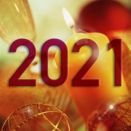 Year 2021 on a background of Christmas elements in warm tones and slightly out of focus.