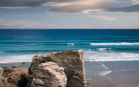 View of Playa de las Catedrales in Ribadeo, Galicia, with the sea in the background and cloudy sky.の写真素材