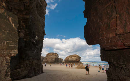 View of the Playa de las Catedrales in Ribadeo, Galicia, with the sea in the background and tourists strolling.のeditorial素材