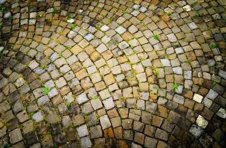 Stone cobblestone pattern in warm tones with texture on the floor of a street in the Swiss city of...
