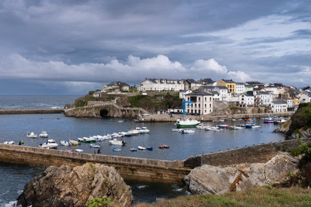 View of the port and the Asturian village of Tapia de Casariego in the background with cloudy skies.のeditorial素材