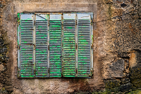 Window in a stone wall. Rural architecture in Spain abandoned and semi-demolished due to migration...