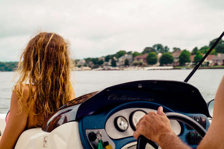 Dirty Blonde Girl Looking out over the Lake on a Speed Boatの写真素材