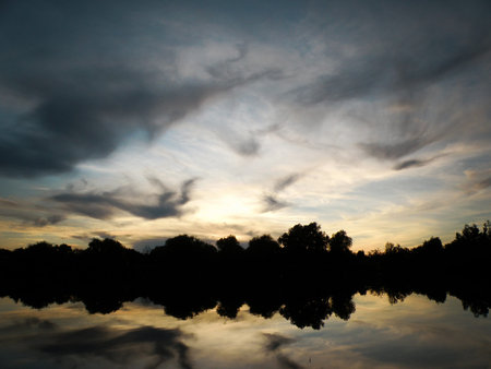 Blue and yellow sunset sky with clouds reflecting at the lake
