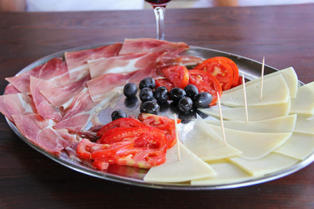 Mediterranean Plate with Prosciutto, Cheese, Olives and Fresh Tomatoesの写真素材
