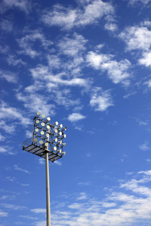 a football stadium floodlight against a cloudy blue skyの写真素材