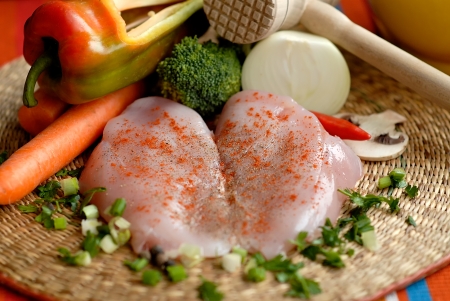 Raw chicken breast arranged wit  1075; vegetables peppers, onions, carrots, mallet, mushrooms on a wooden bowlの写真素材