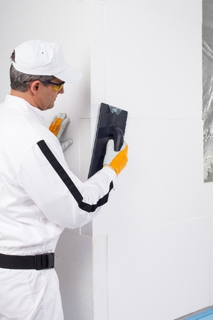 Worker rasping the corners of insulation panelsの写真素材