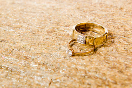 Wedding rings on a natural stone with inclusions of native gold. Offer hands and heartsの写真素材