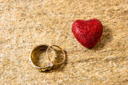 Wedding rings on a natural stone with inclusions of native gold. Offer hands and heartsの写真素材