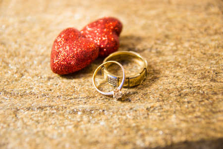 Wedding rings on a natural stone with inclusions of native gold. Offer hands and heartsの写真素材