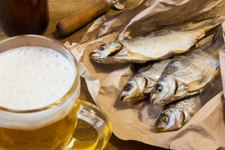 Traditional Russian snacks to beer. Dried roach on paper.