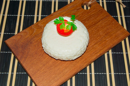 Young oak cheese cutting board with tomatoes and parsley. Mozarella for pizzas and salads.
