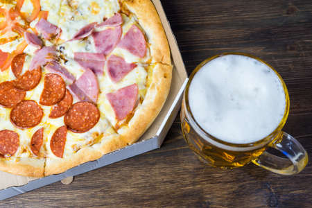 Light beer in glass and fragrant Italian pizza.の写真素材