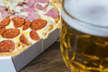 Light beer in glass and fragrant Italian pizza.の写真素材