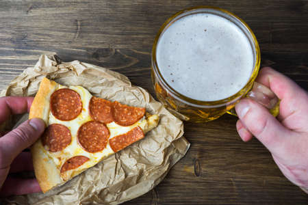 Light beer in glass and fragrant Italian pizza.の写真素材