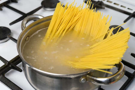 Spaghetti cooked in boiling water on a gas stove. The traditional Italian food.の写真素材