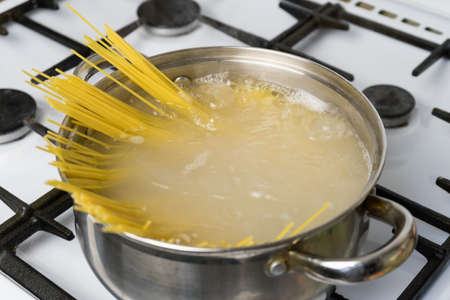 Spaghetti cooked in boiling water on a gas stove. The traditional Italian food.の写真素材
