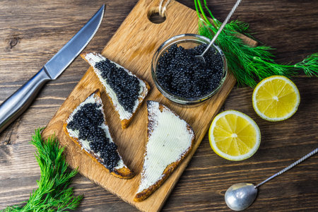 Black caviar on a sandwich. Put a silver spoon on the sandwich.