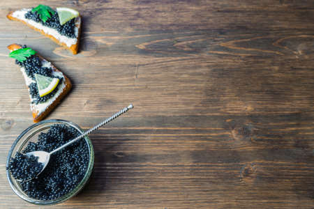 Black caviar on a sandwich. Put a silver spoon on the sandwich.の写真素材