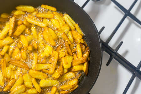 Fry potatoes in a frying pan on a gas stove...の写真素材