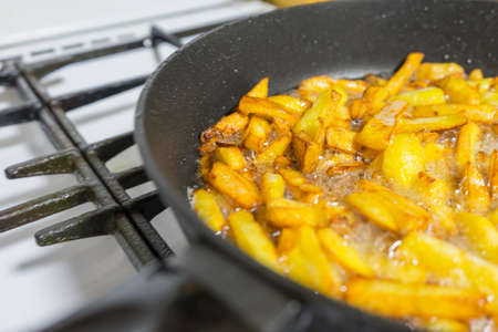 Fry potatoes in a frying pan on a gas stove...の写真素材