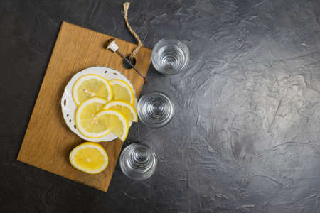 Glass of vodka. And lemon slicing on a plate. Place for your text.,,の写真素材