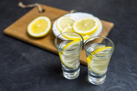 Glass of vodka. And lemon slicing on a plate. Place for your text.,,