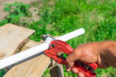 Picture of cutting plastic pipe by special red scissorsの写真素材