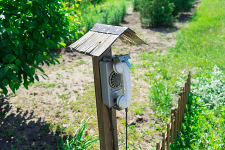 Old street disk wired phone. The village telephone booth.の写真素材