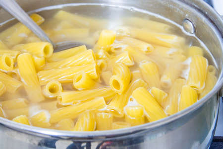 Spaghetti cooked in boiling water on a gas stove. The traditional Italian food.の写真素材
